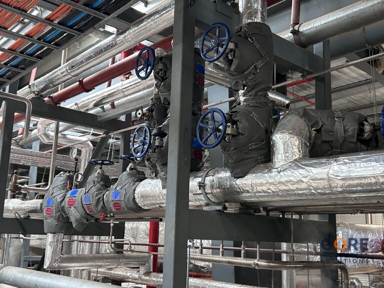 Overhead industrial pipe system fitted with insulation covers and valve wheels